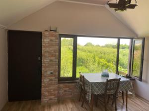 a dining room with a table and a view of a vineyard at ARM Garden EVN Zvartnots in Pʼarakʼar +5 photos