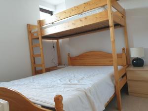 a bedroom with two bunk beds with white sheets at Plein Ciel sur les pistes 40m2 - 2 chambres in Allevard