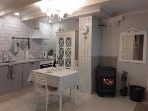 a kitchen with a table and a fire place at Maison Romantique in Ragaciems +6 photos