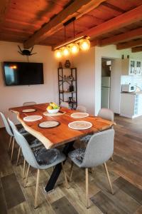 a wooden dining room table with chairs and a television at North Resorts Lucas in Novoť +21 photos