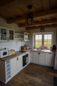 a large kitchen with white cabinets and a window at North Resorts Lucas in Novoť