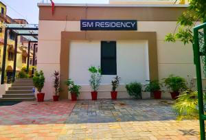 un edificio con piante in vaso di fronte di SM Residency a Bhubaneshwar