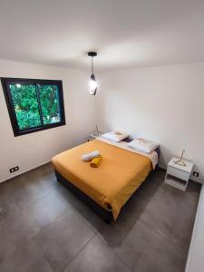 a bedroom with a large bed with a yellow blanket at La Caz' Miness in Saint-Louis