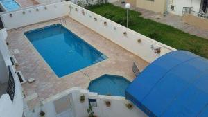 an overhead view of a swimming pool with an umbrella at Adam beautiful loft in Nabeul