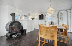 a kitchen and dining room with a wood stove at Beautiful Home In Fanø With Sauna in Fanø