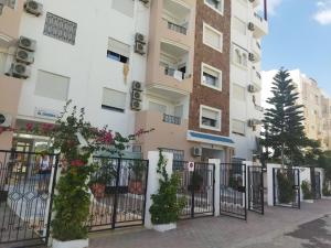 a building with a fence and some plants at Adam beautiful loft in Nabeul