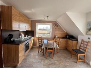 a kitchen with wooden cabinets and a table and chairs at Seestern in Norddeich