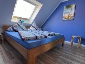 a bedroom with a bed with blue walls and a window at Seestern in Norddeich