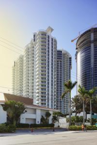 eine Gruppe von hohen Gebäuden mit Palmen in der Unterkunft Marenas Beach Resort Private Luxury Suites in Miami Beach