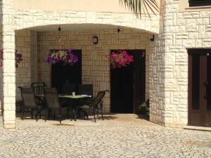 a patio with a table and chairs and flowers at Apartments Villa Kristina in Pula