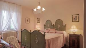 a bedroom with a bed and a chandelier at IL CERRETO 11, Emma Villas in Pontedera +36 photos