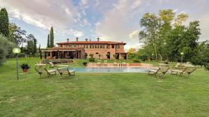 a house with a pool and chairs in the yard at IL CERRETO 11, Emma Villas in Pontedera