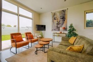 a living room with a couch and a table and chairs at Chalet Aleblie in Susteren