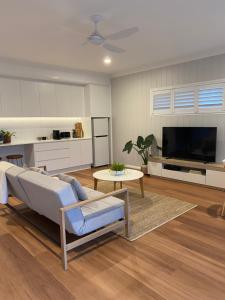 a living room with a couch and a tv at Tweed River Holiday House in Tweed Heads