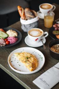 a table with plates of food and cups of coffee at TRIFORET alpin resort by Falkensteiner in Hinterstoder