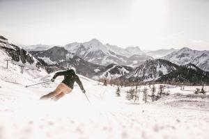 a man is skiing down a snow covered mountain at TRIFORÊT alpin resort in Hinterstoder +114 photos