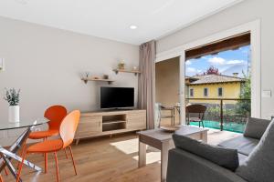 リャネスにある2 Plazas 3 Ballota sin jardin Bのテレビとテーブルと椅子のあるリビングルーム