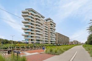 a tall apartment building with a sidewalk in front of it at Vakantie-B'lankenberge The One in Blankenberge