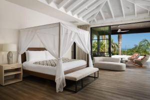 a bedroom with a canopy bed and a living room at COMO Parrot Cay in Sandy Point +248 photos