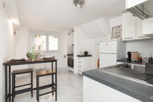 a kitchen with white cabinets and a counter top at Rifugio storico a 50 passi dal Duomo, Bilocale in Genoa