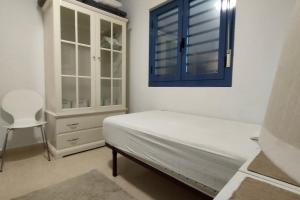 1 dormitorio con cama y ventana azul en Sunny, center Albir apartment, en Alfaz del Pi