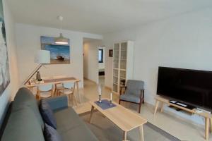 Una sala de estar con un sofá y un televisor de pantalla plana. en Sunny, center Albir apartment, en Alfaz del Pi