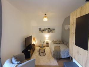 a small bedroom with a bed and a couch at Un Appart' à la campagne in Mordelles