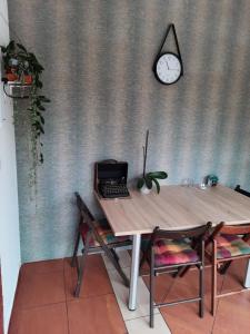 a table with a laptop computer on it next to a clock at Wymój Park in Stawiguda