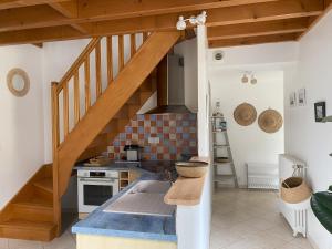 a kitchen with a staircase and a kitchen with a stove at Terres de Nacre - Hébergement touristique & d'affaires in Ouistreham