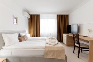 a hotel room with a bed and a desk and a television at Hotel Royal Plaza By TimHotels in Timişoara