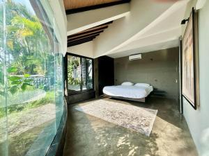 Un dormitorio con una cama y una ventana grande. en View apartments with infinity pool in Nusa Dua Bukit Renovated in 2025, en Nusa Dua 45 fotos más