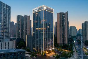 汉阳Qinglian Jinghe Hotel Wuhan Zoo International Expo Center Branch的城市中心的一座高大的玻璃建筑