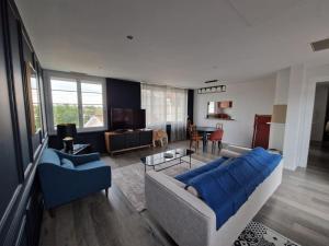 uma sala de estar com um sofá e uma mesa em Superbe Appartement avec terrasse em Libourne