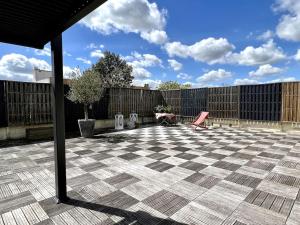 um pátio com uma cadeira rosa e uma cerca em Superbe Appartement avec terrasse em Libourne