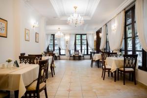 a restaurant with tables and chairs and a chandelier at Hotel Royal Plaza in Timişoara