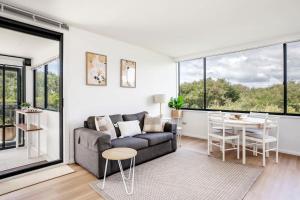 a living room with a couch and a table at Mona Vale Surf to Tee in Mona Vale