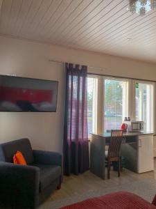 a living room with a table and a chair and a desk at Safarimajoitus in Kalajoki +6 photos