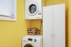 a laundry room with a washer and a washing machine at Beach Baby - Close to Cylinder Beach in Point Lookout