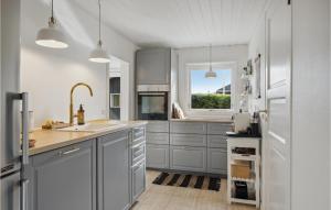 una cucina con armadi grigi e una finestra di 2 Bedroom Cozy Home In Juelsminde a Sønderby