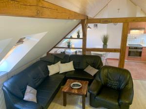 a living room with a black leather couch and a table at Ferienwohnung Inge in Malchow