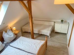 a attic bedroom with two beds and a table at Ferienwohnung Inge in Malchow