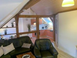 a living room with a couch and a kitchen at Ferienwohnung Inge in Malchow +5 photos