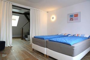 a bedroom with a bed with blue sheets on it at Ferienhaus Blaues Häuschen in Freudenberg am Main