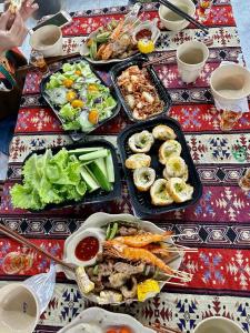 a table topped with dishes of food on a table at Hoa Anh Đào Homestay in Kon Von Kla
