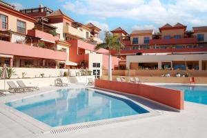an image of a swimming pool in front of a building at Terrazas del Duque Beach Apartment in Adeje