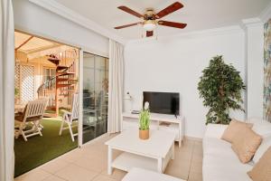 a living room with a white couch and a ceiling fan at Terrazas del Duque Beach Apartment in Adeje
