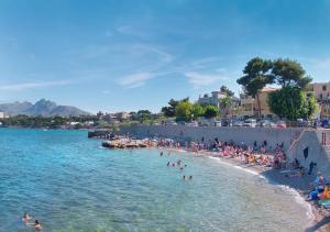 a group of people on a beach in the water at Solemar Sicilia - Casa Emma in Porticello