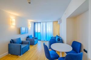a waiting room with blue chairs and a white table at Orbi City Amazing Apartments in Batumi