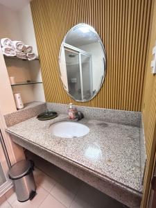 a bathroom counter with a sink and a mirror at Serendipity Homestay Oakhill 514,Bristle Ridge Condominium, Baguio City in Baguio +25 photos