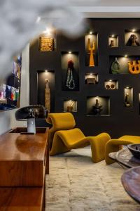 a living room with yellow furniture and a black wall at Riad SASHA Exclusive&New Pool 6 pax Free Breakfast in Marrakech
